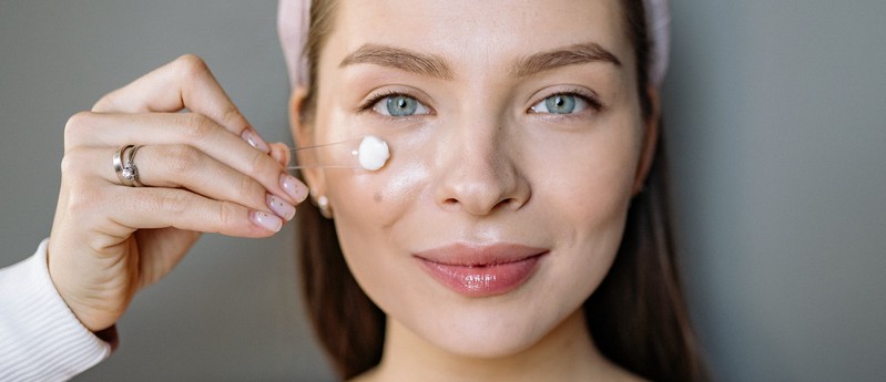 Femme qui applique de la crème sur son visage